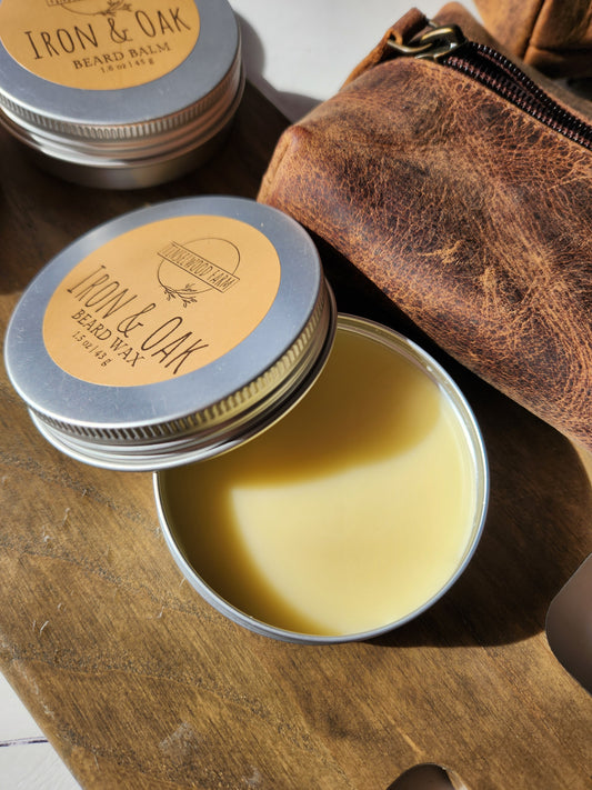 Two tins of Iron & Oak wax on a wooden surface with a leather pouch.