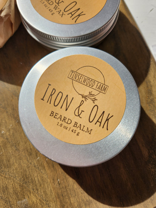 Two tins of Iron & Oak beard balm on a wooden surface